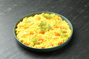 Delicious pumpkin risotto in bowl on black table, closeup