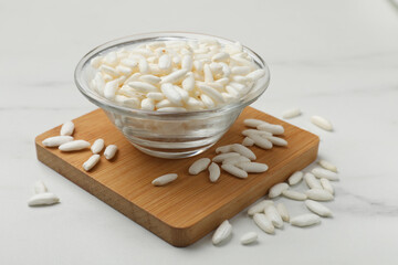 Puffed rice in bowl on white table, closeup