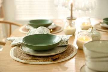 Stylish table setting with dishware, cutlery and burning candles indoors