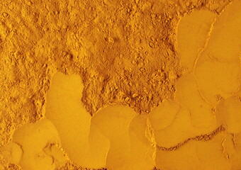 Turmeric powder pile background and texture, top view	