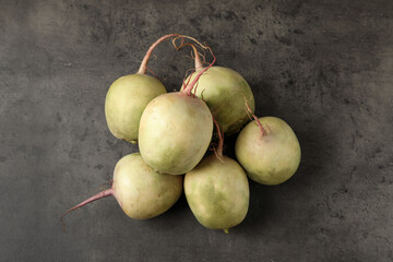 Whole fresh ripe turnips on grey table, top view