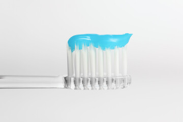 One toothbrush with toothpaste in air on white background, closeup