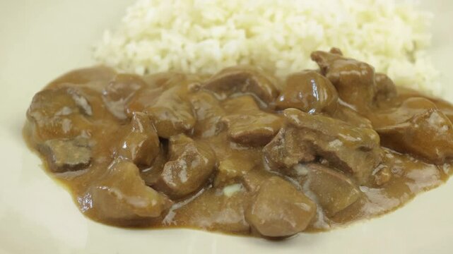 rognons de boeuf en sauce et riz dans une assiette