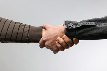 Help and support. People holding hands on light grey background, closeup