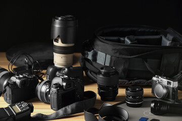 Professional photographer's equipment and backpack on wooden table