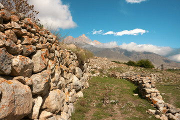 Panoramic view of the ruins of an old mountain village in Upper Balkaria, Kabardino-Balkaria. Outlines of stone dwellings against the background of picturesque mountains.