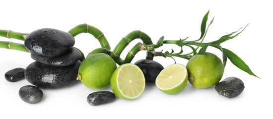 Spa composition with limes, massage stones and bamboo stems isolated on white