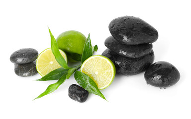 Spa composition with limes, massage stones and green leaves isolated on white