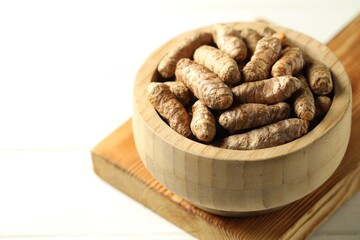 Raw tumeric rhizomes on white table, closeup. Space for text