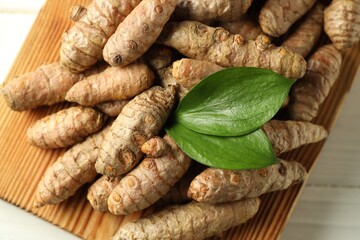 Raw tumeric rhizomes on white table, closeup