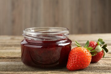 Delicious strawberry sauce and fresh berries on wooden table, closeup