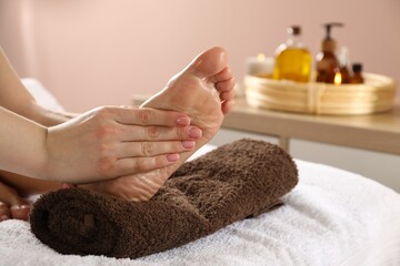 Woman receiving foot massage in spa salon, closeup