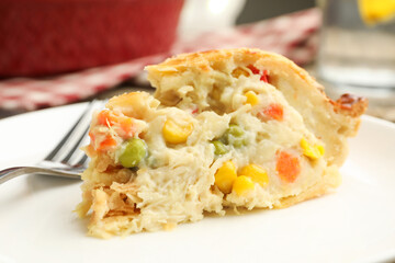 Piece of tasty homemade pie with chicken and vegetables on plate, closeup