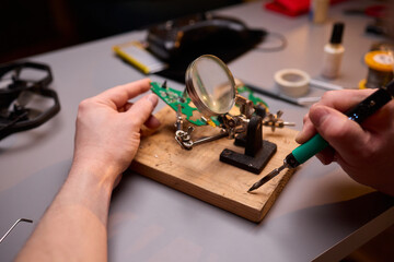 Hands Carefully Repairing a Circuit Board with a Soldering Tool for Electronics Projects