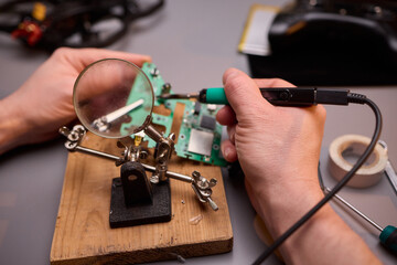 Hands Carefully Repairing a Circuit Board with a Soldering Tool for Electronics Projects