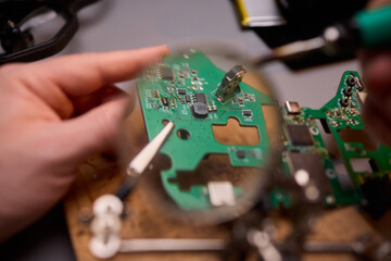 Hands Carefully Repairing a Circuit Board with a Soldering Tool for Electronics Projects