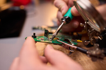 Hands Carefully Repairing a Circuit Board with a Soldering Tool for Electronics Projects