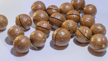 A top view of a bunch of macadamia nuts resting on a uniform background, showcasing their rich texture and natural color. Perfect for food-related designs and healthy snack concepts.