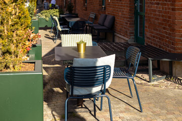 Outdoor street cafe tables ready for service. Empty cafe terrace with table and plastic chair, morning time. Food concept