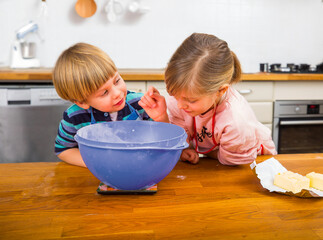 Two Children Baking Together in a Bright Modern Kitchen Environment