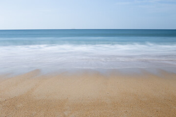 Beach seascape with ocean or sea view. Long exposure with wave movement on the sand. Beautiful summer vacation landscape.