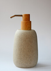 A beautifully designed soap dispenser featuring a textured stone body with a wooden pump and stainless steel spout