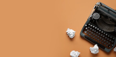 Vintage typewriter and crumpled paper on orange background with space for text, top view