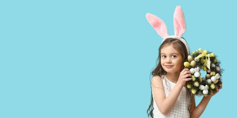 Cute little girl with Easter wreath and bunny ears on light blue background with space for text