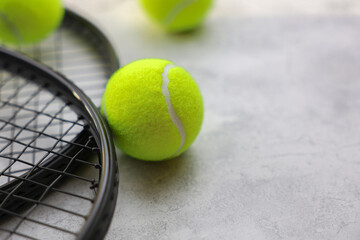 Two tennis rackets lie on the left side of the photo, on and next to them are yellow tennis balls in close-up with space for text. High quality photo