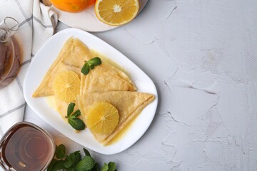 Delicious Crepes Suzette served on white textured table, flat lay. Space for text