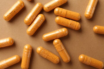 Turmeric capsules on beige background, flat lay