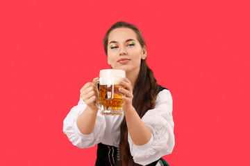 Young Irish woman with mug of beer on red background. St. Patrick's Day celebration