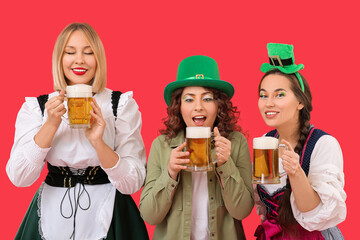 Portrait of happy women with beer celebrating St. Patrick's Day on red background