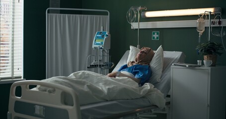 Hospitalized Arab woman, scrolling through her phone.