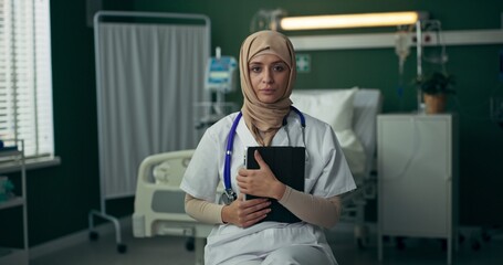 Arab doctor in hospital uses a tablet to coordinate treatment plans and review medical histories.