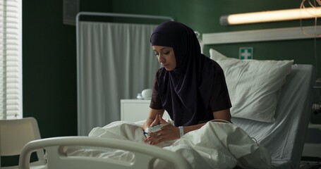 Arab patient in the hospital ward gazes sadly at the camera.