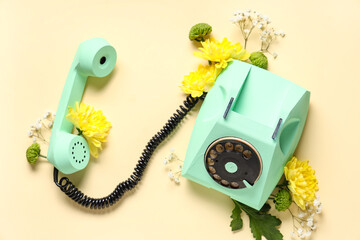 Retro telephone with beautiful gypsophila and chrysanthemum flowers on yellow background. ...