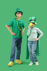 Funny kids with face painting and costumes on green background. St. Patrick's Day celebration