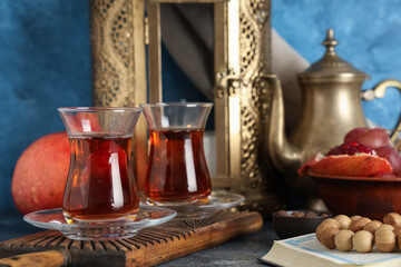 Turkish tea, fruits, Koran and prayer beads and on blue table. Ramadan celebration
