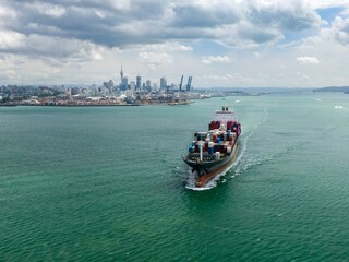 Large cargo ship navigating Waitemata Harbour, New Zealand. Shipping container vessel in transit. International trade.  Auckland, Auckland, New Zealand © Zenstratus