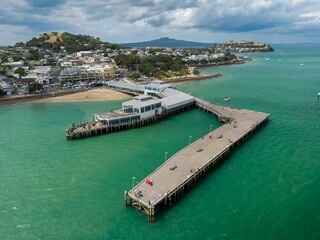 Aerial view of a bustling waterfront with Devonport Ferry Terminal, people fishing, and a town....
