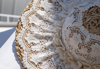 Straw hat with white lace on top, abstract texture details in Greece.