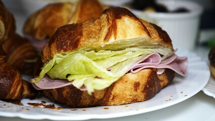 Freshly baked croissant with a creamy filling, perfect for breakfast or dessert, served with a cup of coffee on a rustic wooden table.