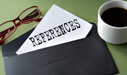 REFERENCES - words on a white sheet of paper on a background of a black convers and a cup of coffee
