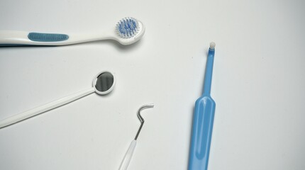 Toothbrush dental mirror. Blue interdental cleaner. Metal scaler hook. White medical background.

