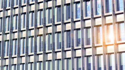 Geometric reflection: Partly cloudy sky reflected by window panes of office building. Surface of...