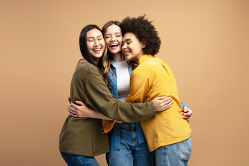 Three happy young women embracing and smiling together