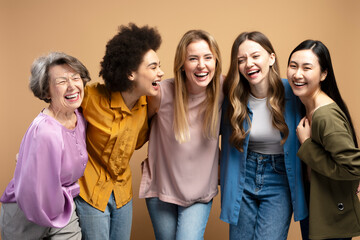 Fototapeta premium Five cheerful multi-ethnic women embracing and laughing together