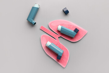 Inhalers and paper lungs on grey background