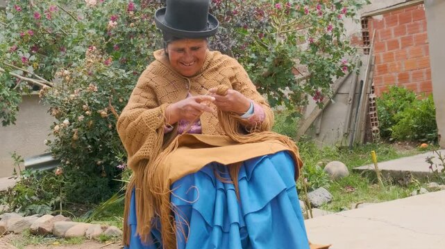 elderly aymara woman in pollera working on wool textiles at home in la paz city, bolivia - work concept